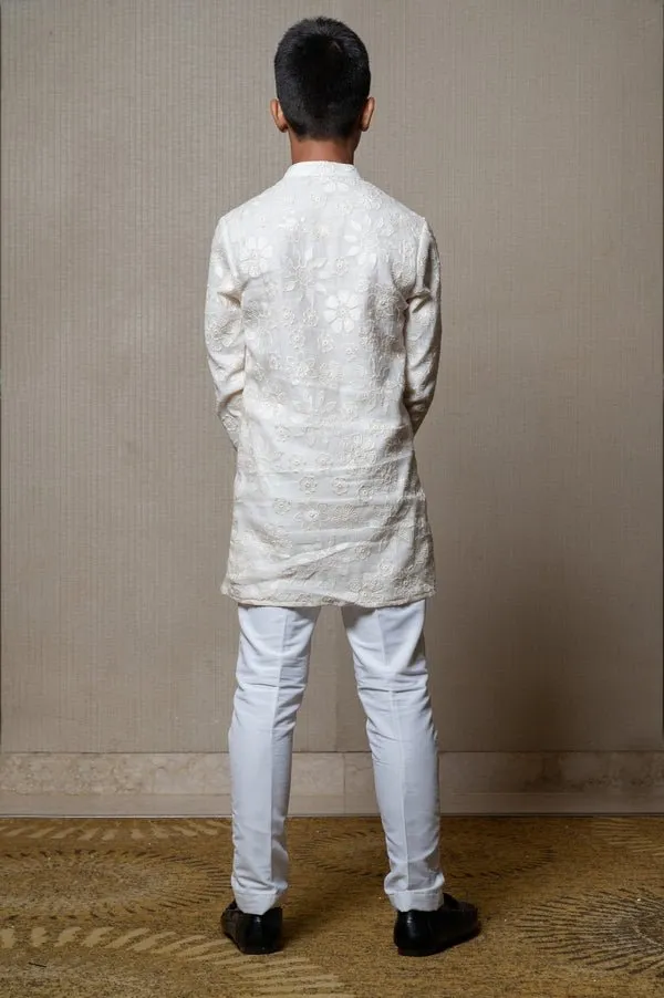 Intricately embroidered off-white bandhgala with matching white kurta and pants for an elegant traditional look